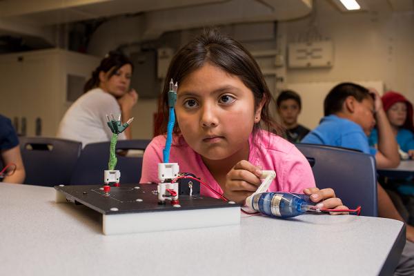 Young student working with circuit board.