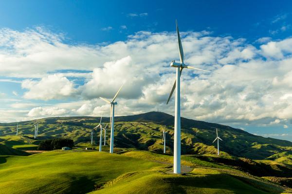 Outside photo of windmills across the landscape during a cloudy day.