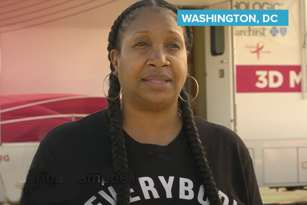 Woman speaking outside next to mammography vehicle.