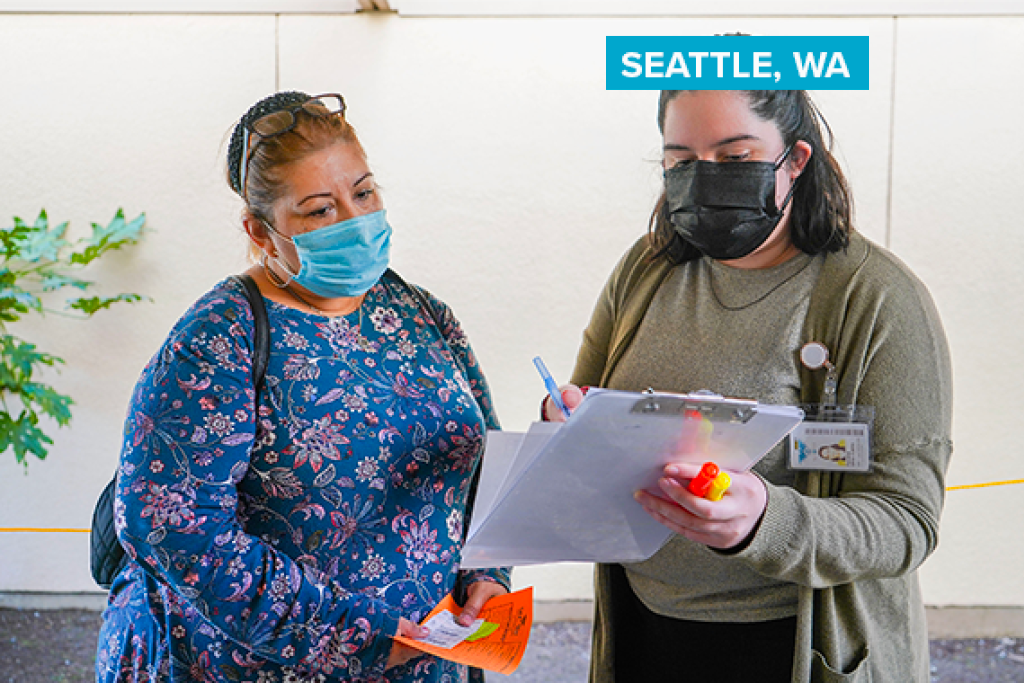 Two masked women speaking