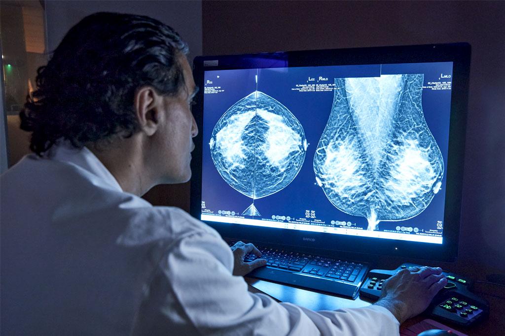 Provider looking at x-ray on monitor in dark office