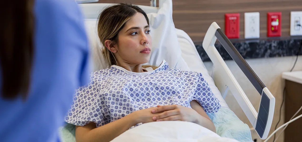 Patient sitting on hospital bed.