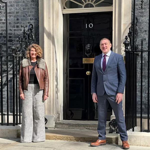 Two people standing in front of door.